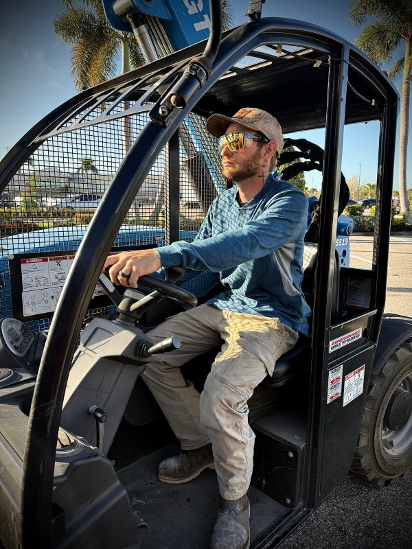 Worker in FR shirt operating a forklift